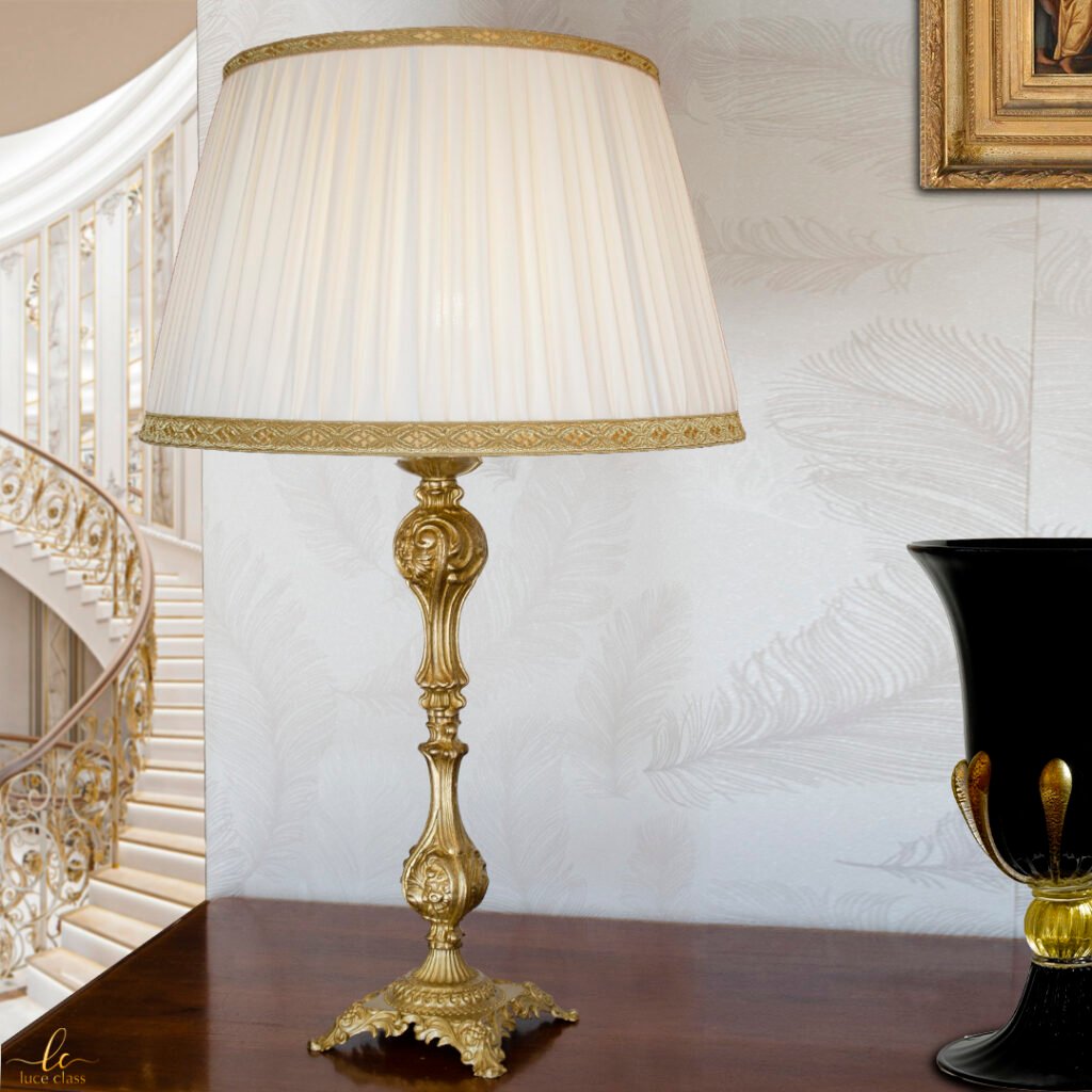 Lampada da tavolo in fusione di ottone satinato con paralume avorio plissettato.