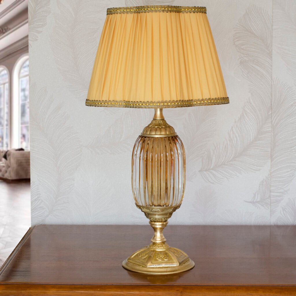 Lampada in vetro di Murano color ambra e ottone satinato, con paralume a Margherita plissè ocra.